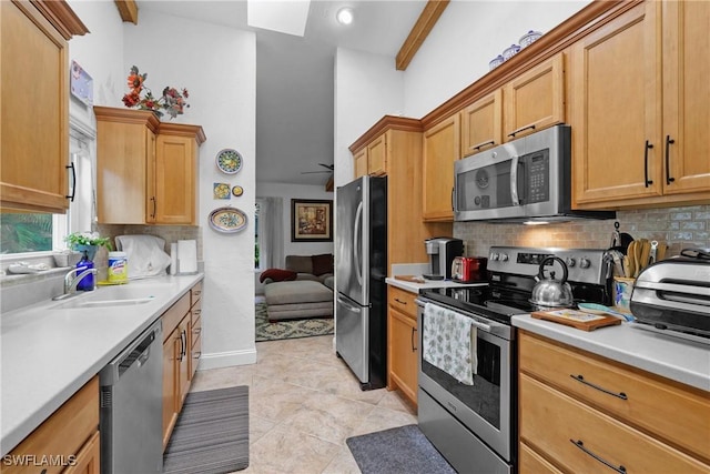 kitchen featuring sink, backsplash, appliances with stainless steel finishes, and beam ceiling