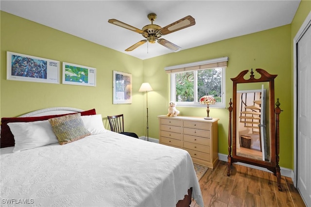 bedroom with a closet, ceiling fan, and dark hardwood / wood-style flooring