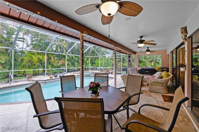 view of patio / terrace with glass enclosure, a swimming pool with hot tub, and ceiling fan