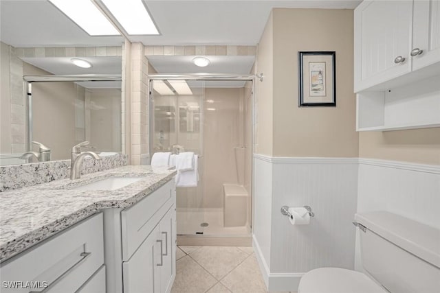 bathroom featuring vanity, toilet, walk in shower, and tile patterned flooring