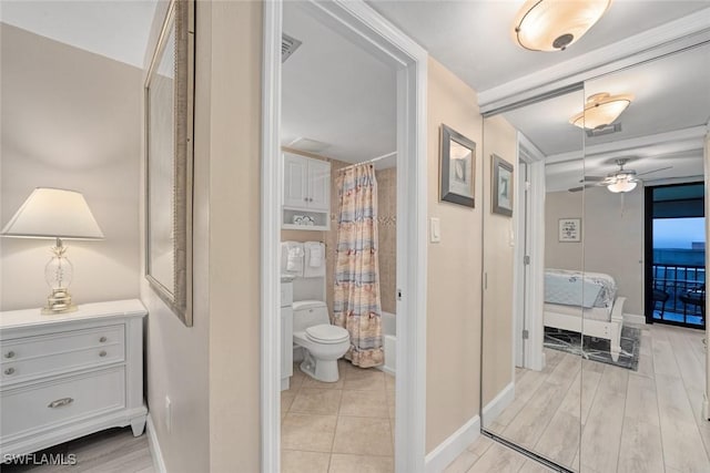 bathroom with ceiling fan, toilet, and shower / tub combo