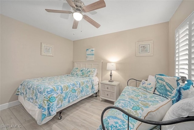 bedroom with light wood-type flooring, ceiling fan, and multiple windows