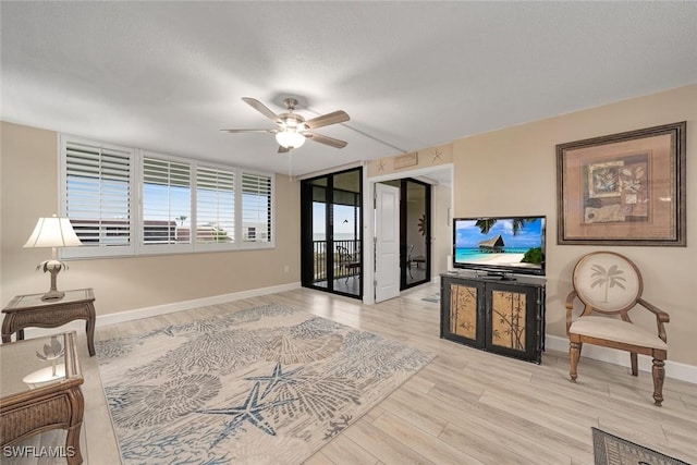 living room with ceiling fan and light hardwood / wood-style floors