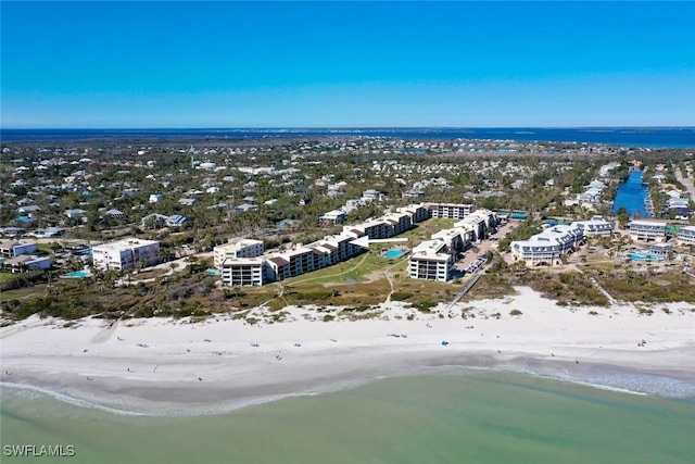 birds eye view of property featuring a water view and a beach view