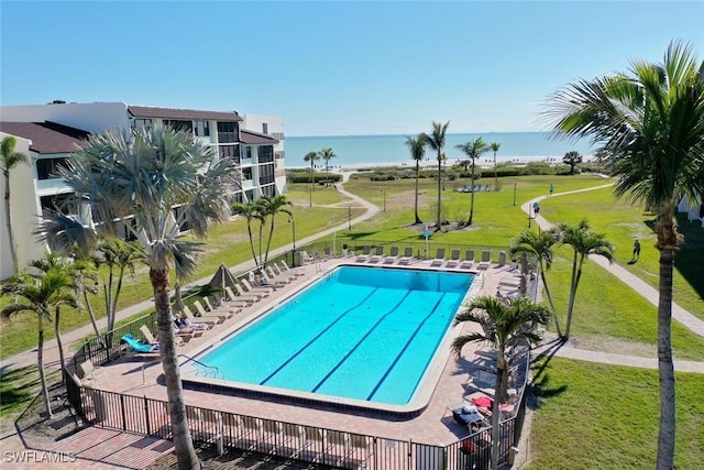 view of swimming pool with a water view, a yard, and a patio area