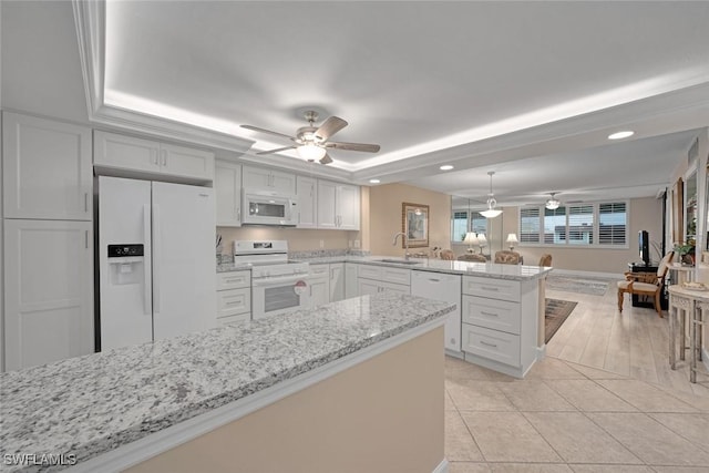 kitchen featuring white cabinetry, white appliances, a tray ceiling, and kitchen peninsula