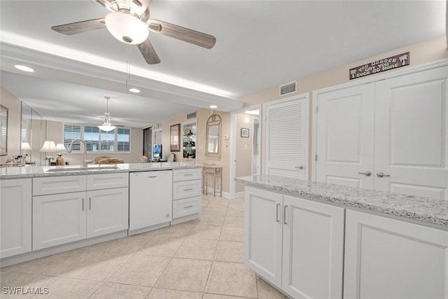 kitchen featuring light stone countertops, white dishwasher, white cabinetry, light tile patterned floors, and sink