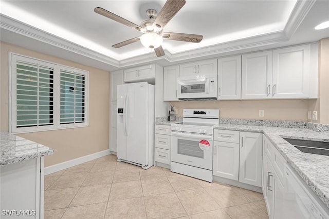 kitchen with light tile patterned floors, white appliances, white cabinets, and a raised ceiling