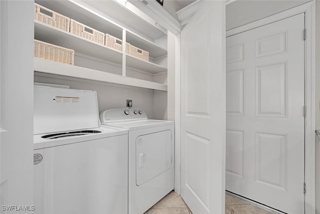 clothes washing area featuring washer and dryer and light tile patterned floors