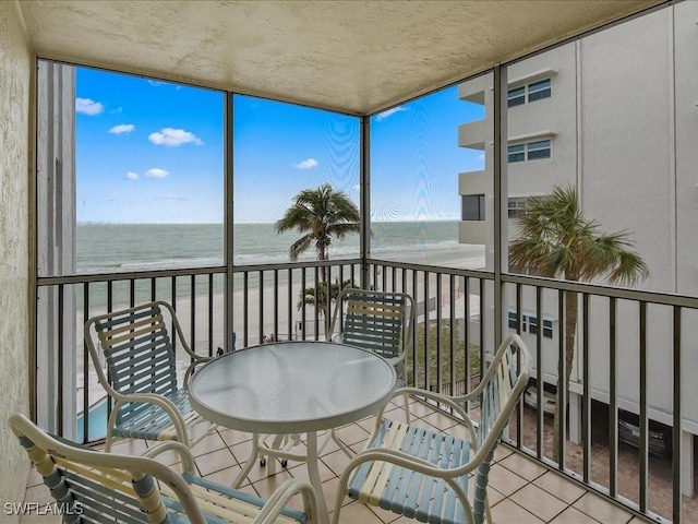 sunroom / solarium with a water view and a view of the beach