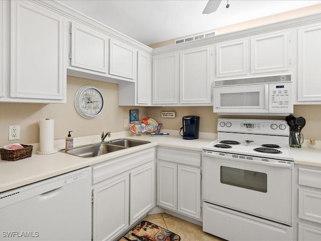 kitchen featuring white appliances, white cabinets, light tile patterned flooring, and sink