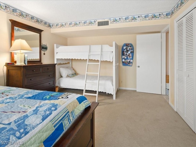 carpeted bedroom with a textured ceiling and a closet