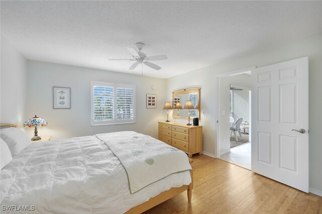 3072 Sandpiper Bay Cir Unit M203, Naples, FL 34112 - bedroom featuring light wood-style floors, a ceiling fan, and a textured ceiling