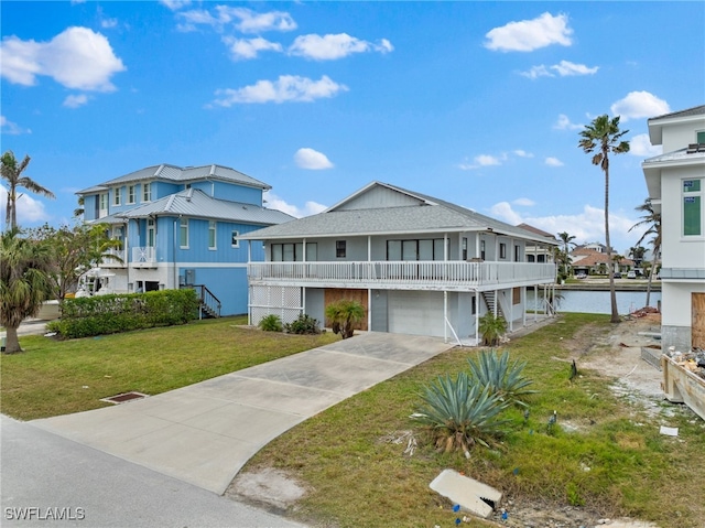 view of front facade featuring a garage, a water view, and a front lawn