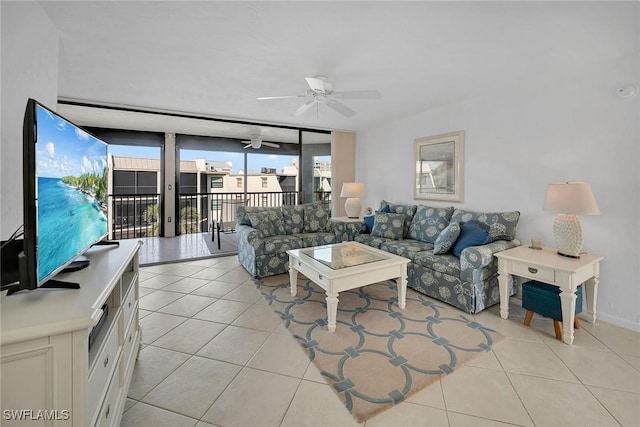 tiled living room featuring ceiling fan and a wall of windows