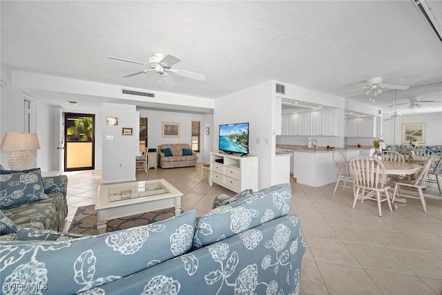 living room featuring a textured ceiling, ceiling fan, and light tile patterned flooring