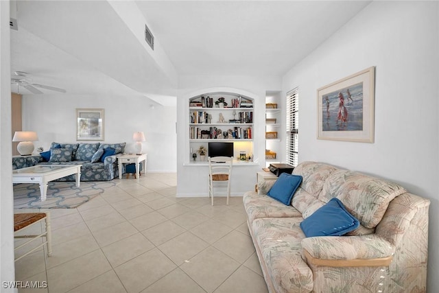 living room featuring ceiling fan, built in shelves, and light tile patterned floors