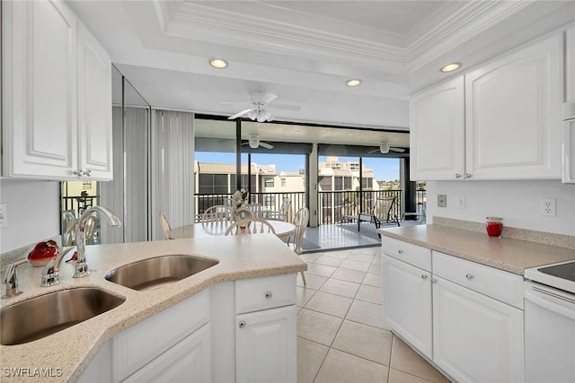 kitchen featuring white cabinets, ornamental molding, light tile patterned flooring, and sink