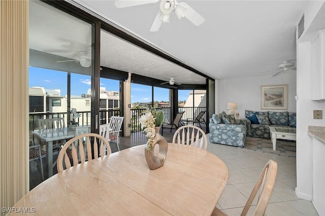 tiled dining space with ceiling fan, a wealth of natural light, and floor to ceiling windows