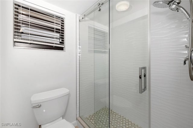 bathroom with toilet and an enclosed shower