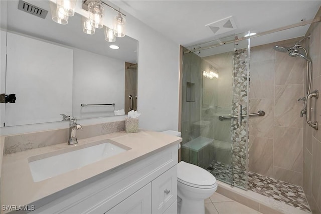 bathroom with toilet, vanity, tile patterned floors, and a shower with shower door