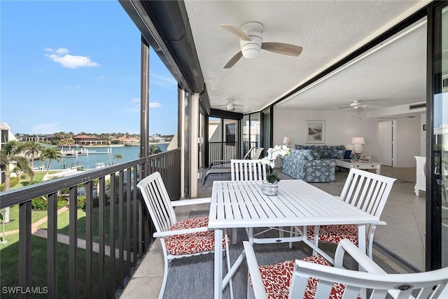 balcony with ceiling fan, a water view, and an outdoor hangout area