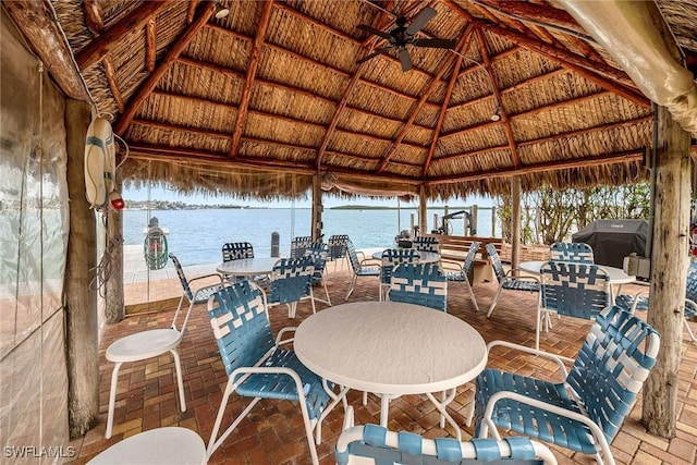 deck with ceiling fan, a water view, a grill, and a gazebo