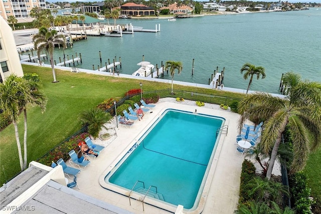 view of swimming pool with a patio, a yard, and a water view