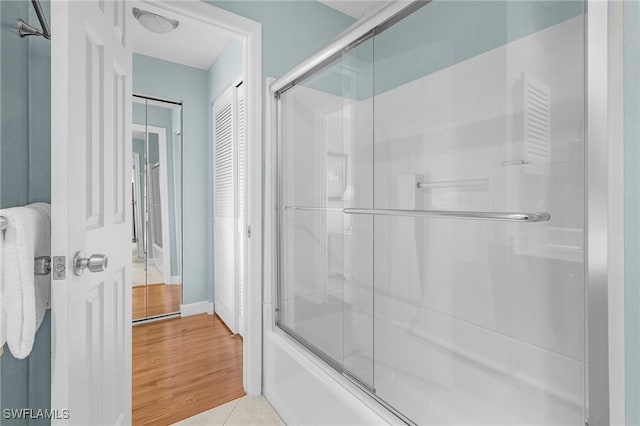 bathroom featuring shower / bath combination with glass door and tile patterned floors