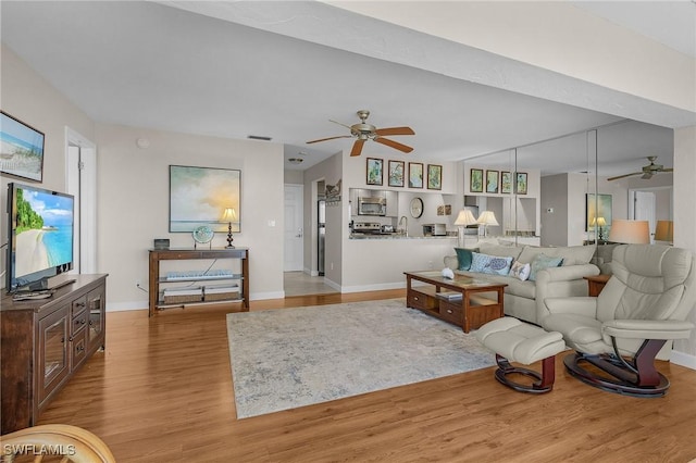 living room featuring ceiling fan and light hardwood / wood-style flooring