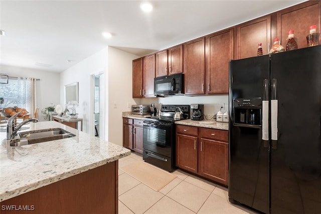 kitchen with sink, light tile patterned flooring, black appliances, and light stone countertops