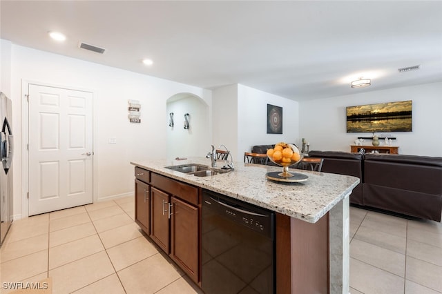 kitchen with light stone countertops, dishwasher, a center island with sink, light tile patterned floors, and sink