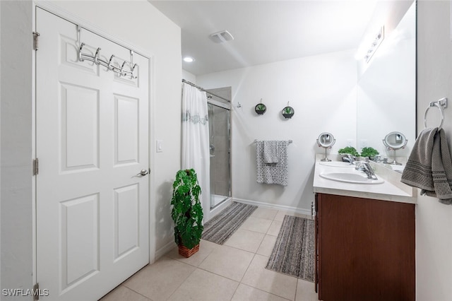 bathroom with tile patterned flooring, an enclosed shower, and vanity