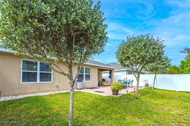 rear view of property featuring a patio area and a lawn