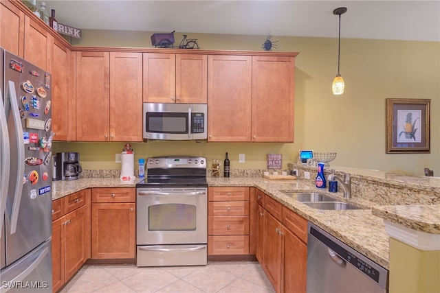 kitchen with pendant lighting, kitchen peninsula, sink, light stone countertops, and stainless steel appliances