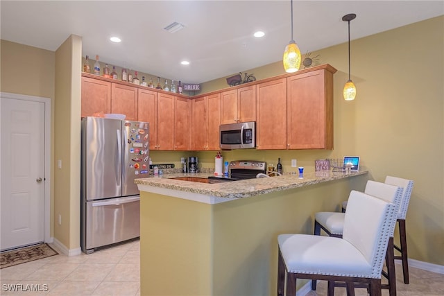 kitchen with decorative light fixtures, stainless steel appliances, kitchen peninsula, light stone counters, and light tile patterned floors