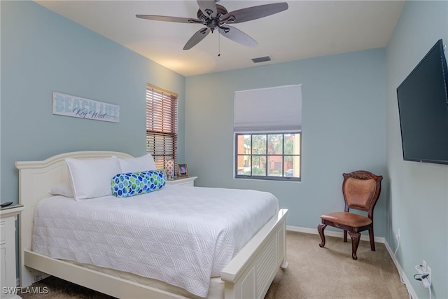 bedroom with ceiling fan, multiple windows, and light carpet