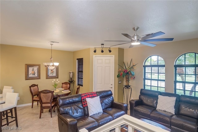 tiled living room with a textured ceiling and ceiling fan with notable chandelier