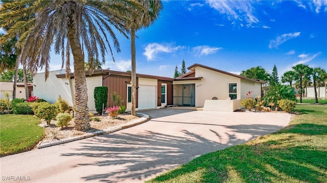 ranch-style home featuring a garage and a front lawn