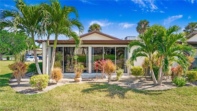 rear view of house featuring a lawn