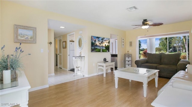 living room with ceiling fan and light hardwood / wood-style flooring