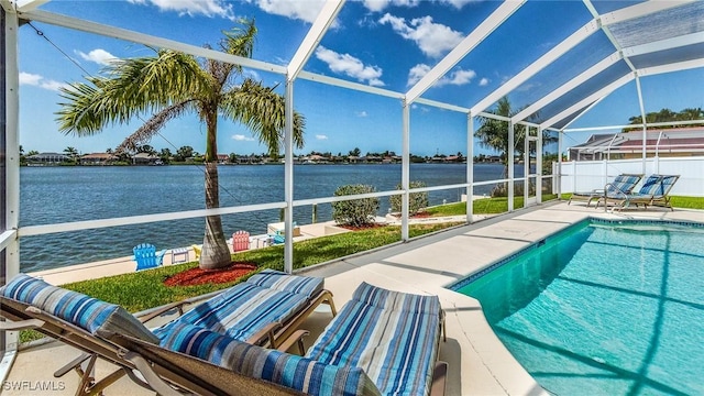 view of swimming pool featuring a patio area, glass enclosure, and a water view