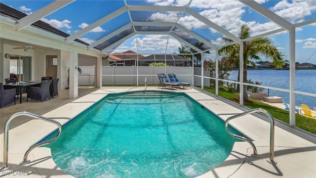 view of pool featuring ceiling fan, a water view, glass enclosure, and a patio area