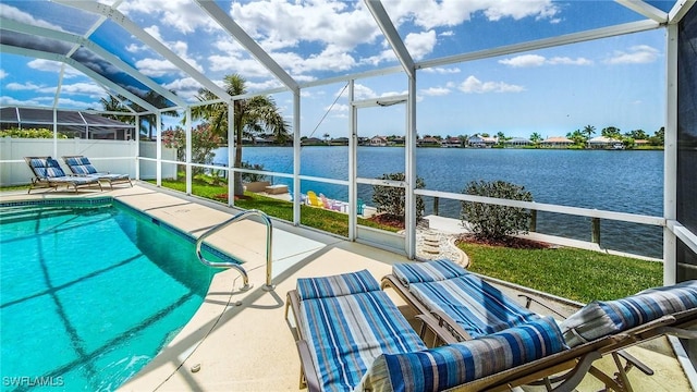 view of swimming pool with a patio, glass enclosure, and a water view