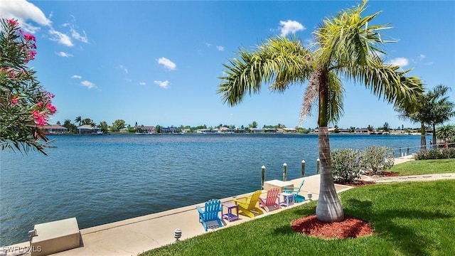 view of dock with a yard and a water view