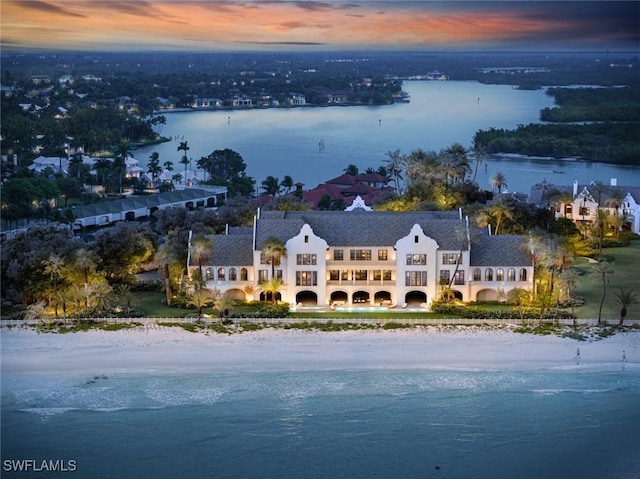 aerial view at dusk featuring a water view