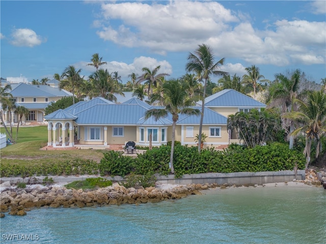 rear view of house with a lawn and a water view