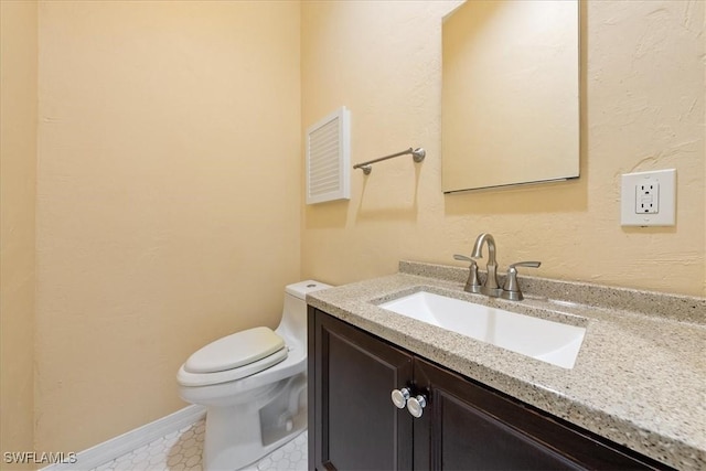 bathroom featuring toilet, vanity, and tile patterned flooring