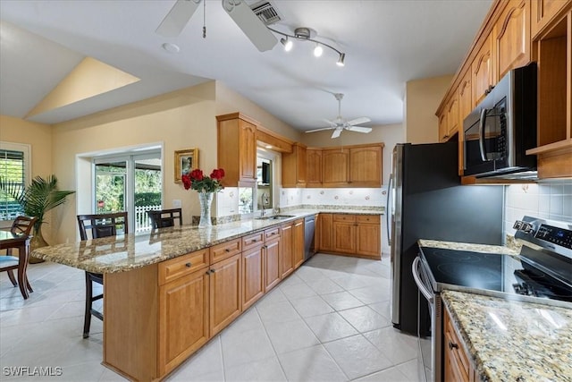 kitchen with kitchen peninsula, a breakfast bar, backsplash, appliances with stainless steel finishes, and sink