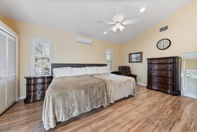 bedroom with ceiling fan, light wood-type flooring, a wall mounted air conditioner, and a closet